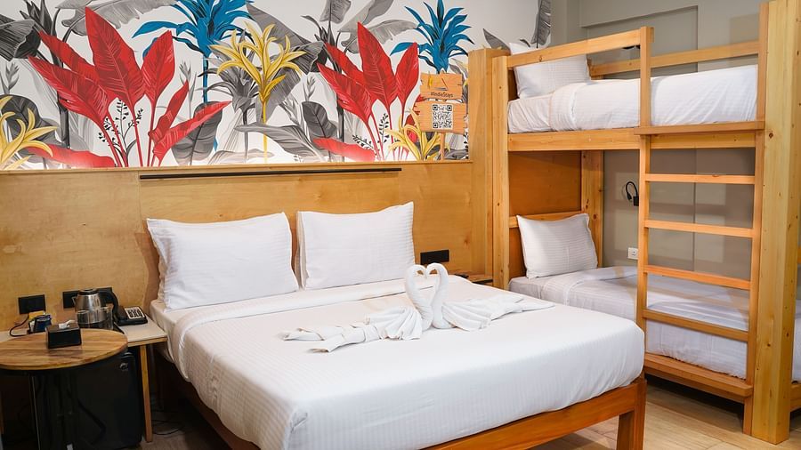 A large bed next to bunk beds in Urban Corner Family Room at Indie Stays Resort, Goa.